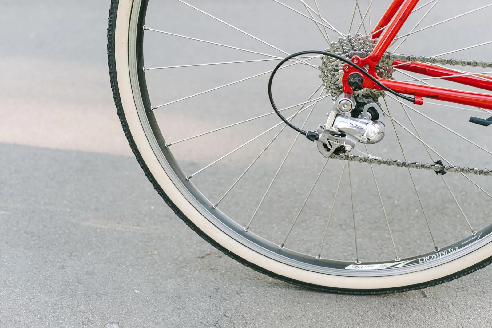 Rear wheel, tyre and drivetrain of a red bicycle